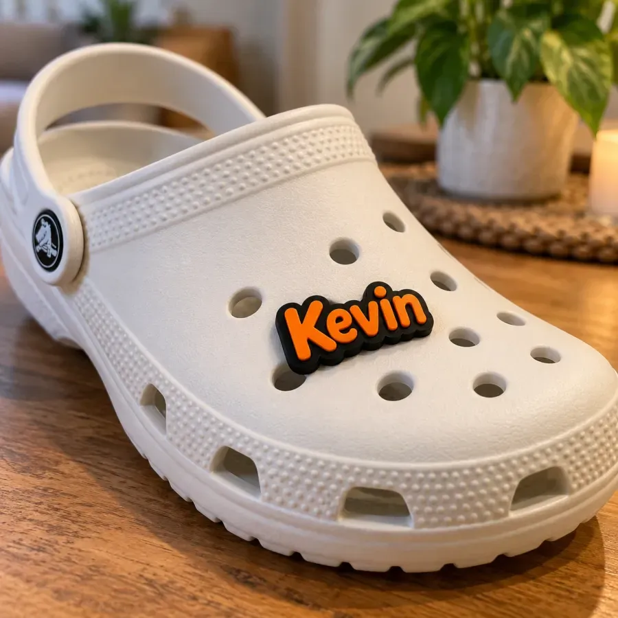 Charm orange avec le prénom Kevin clipsé sur une Crocs blanche
